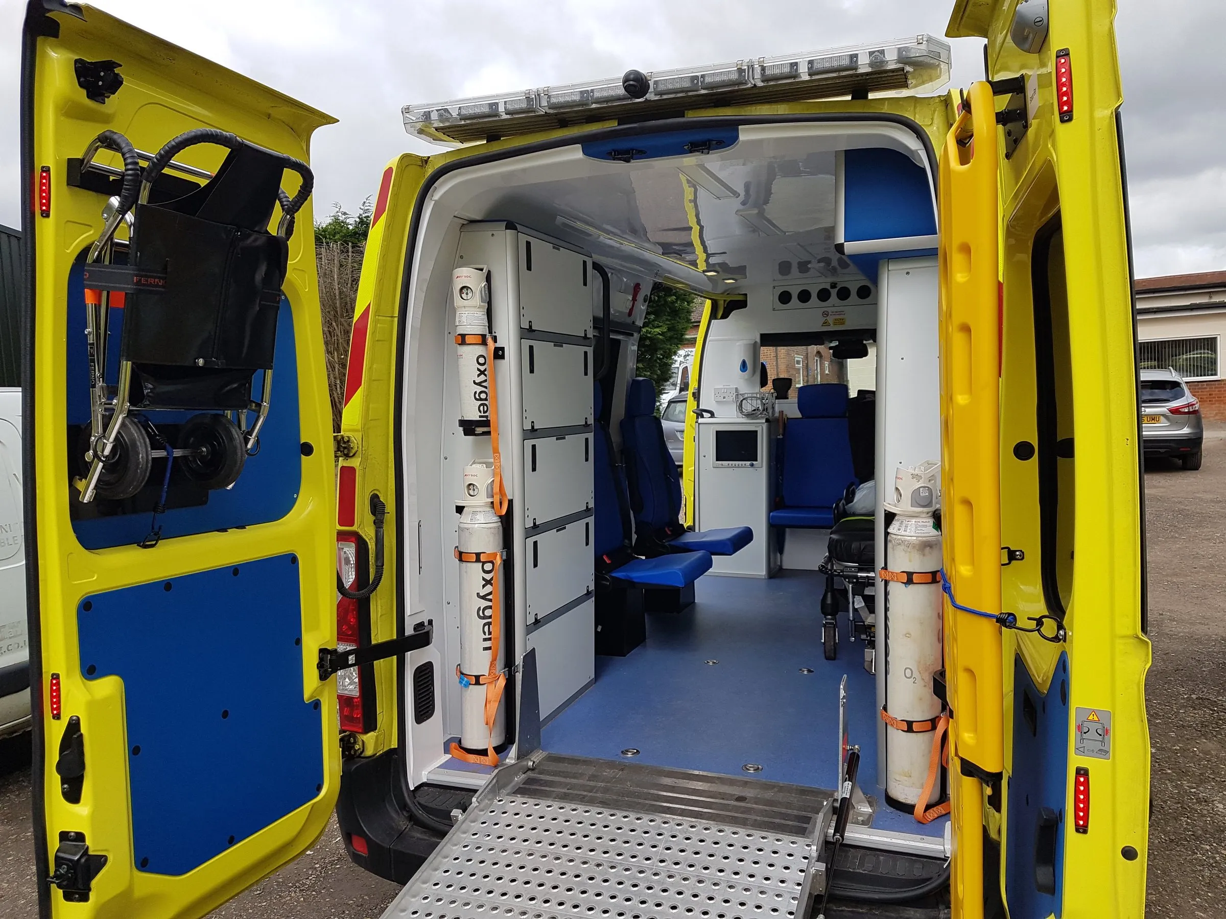 The rear of a Hearts First ambulance with the doors open, showing the stretcher area, seating and oxygen